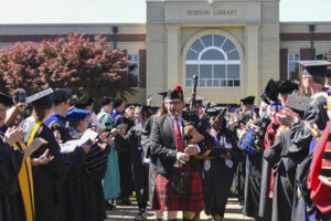 Bagpiper leads students during Commencement 2025
