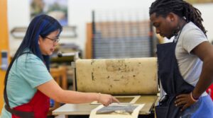 Art professor Tammy Harrington working with a student on an art project