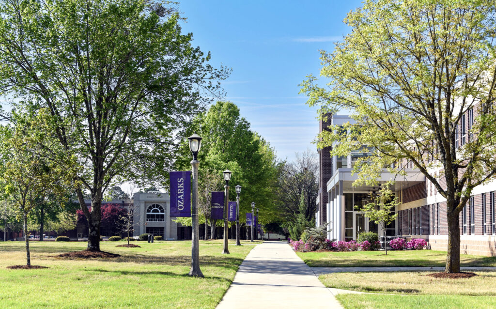 University of the Ozark campus in the spring, showing the library, science center, and purple Ozarks banners.
