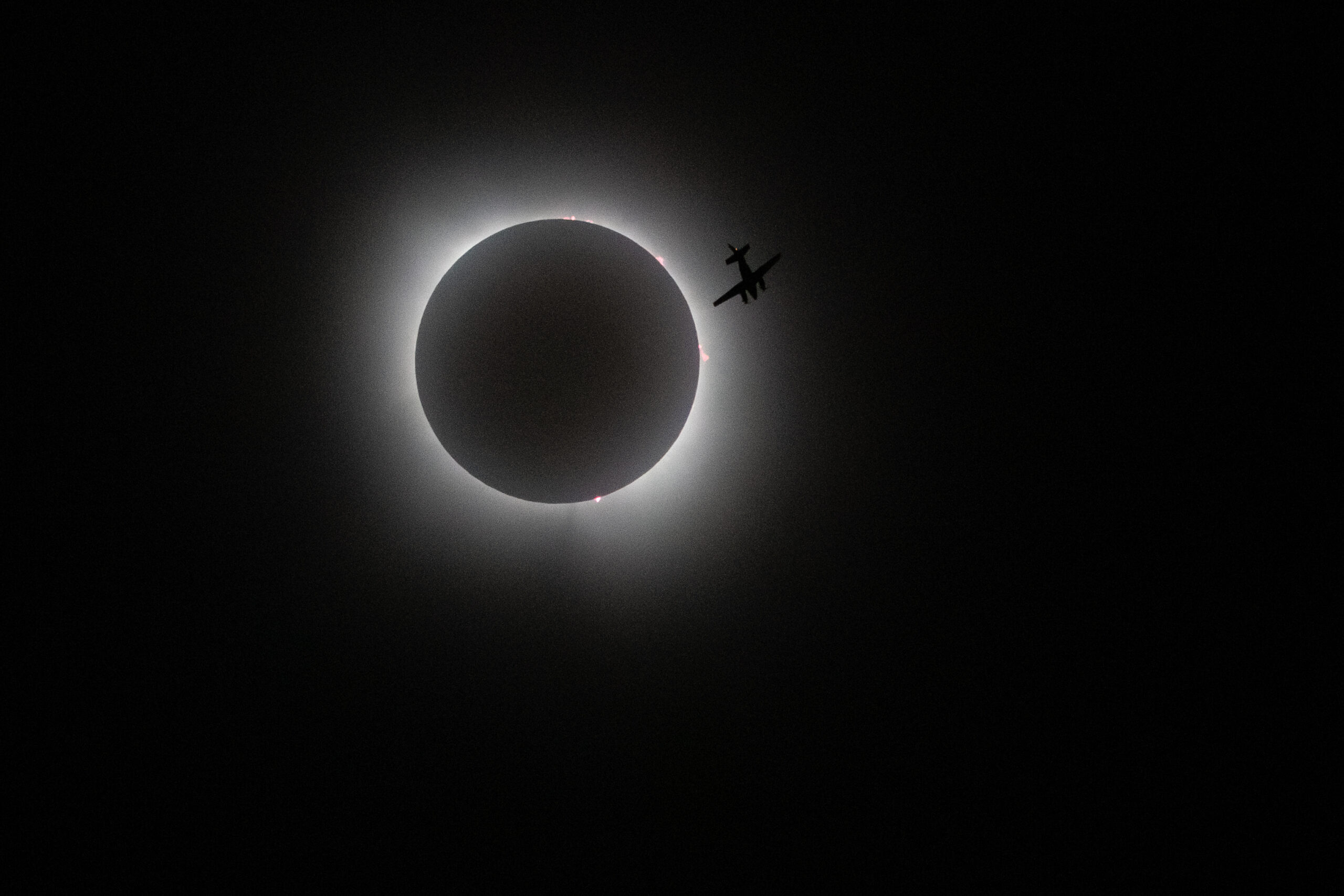 Photography class capture of plane crossing total eclipse
