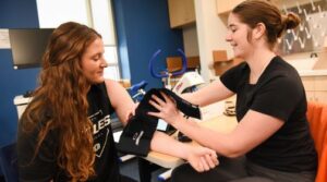 Student taking blood pressure in health science class